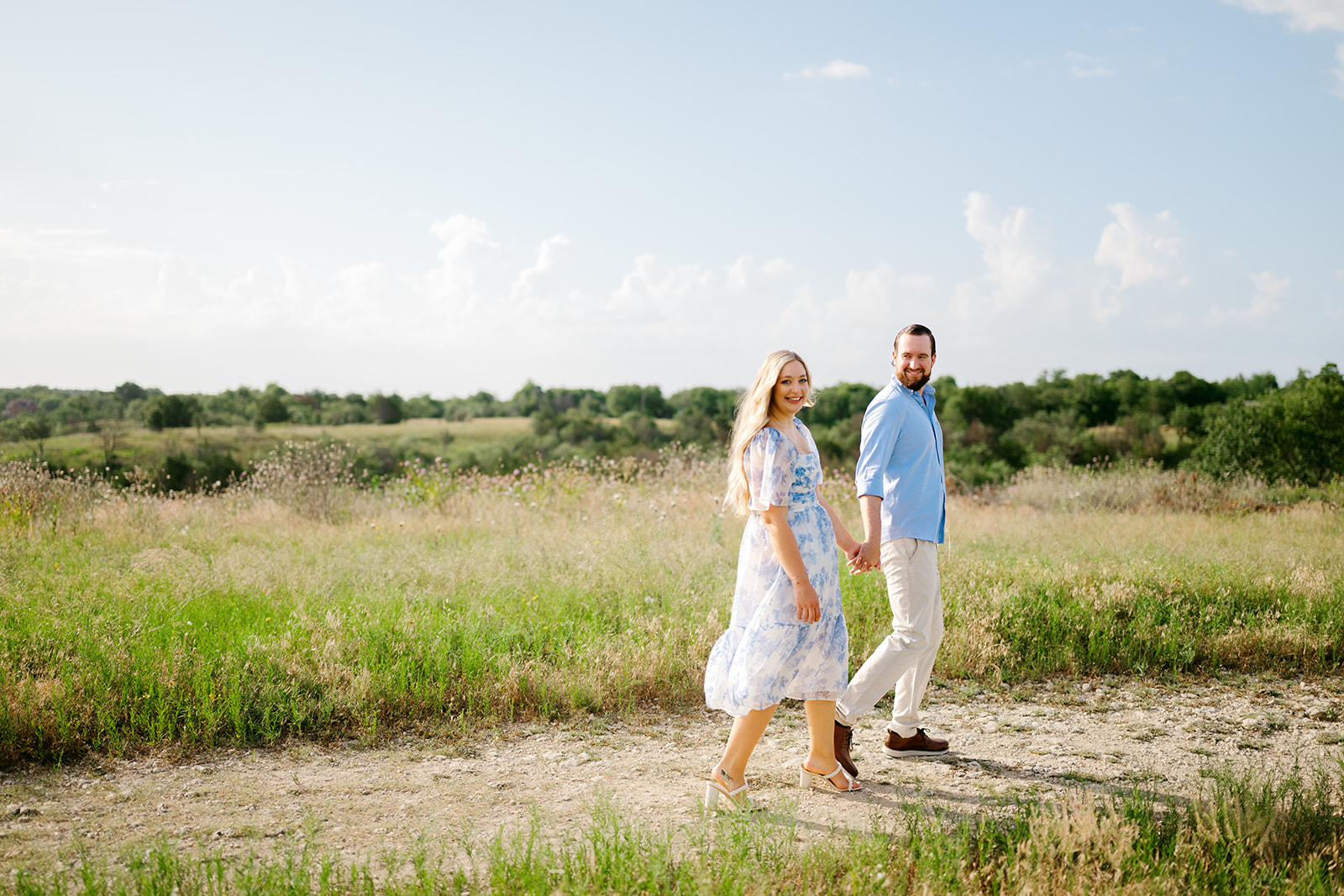Couple walking holding hands in an open field in Texas