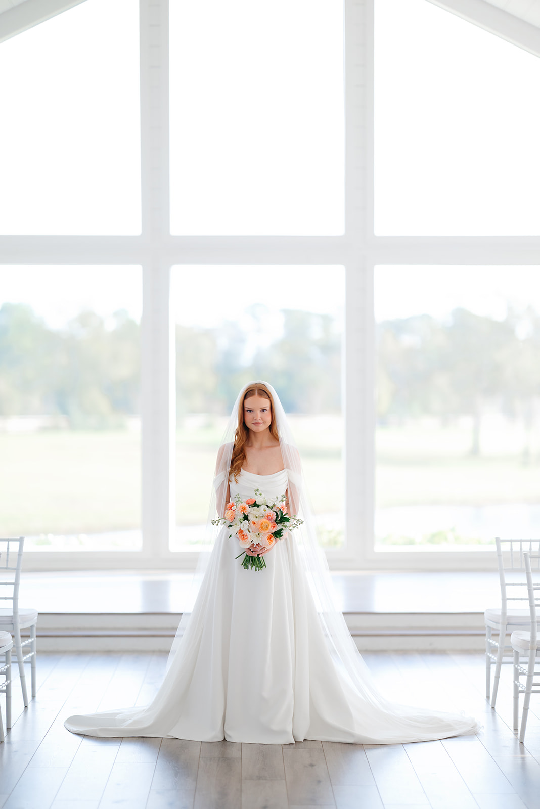 Bride in front of large windows during her bridal portraits