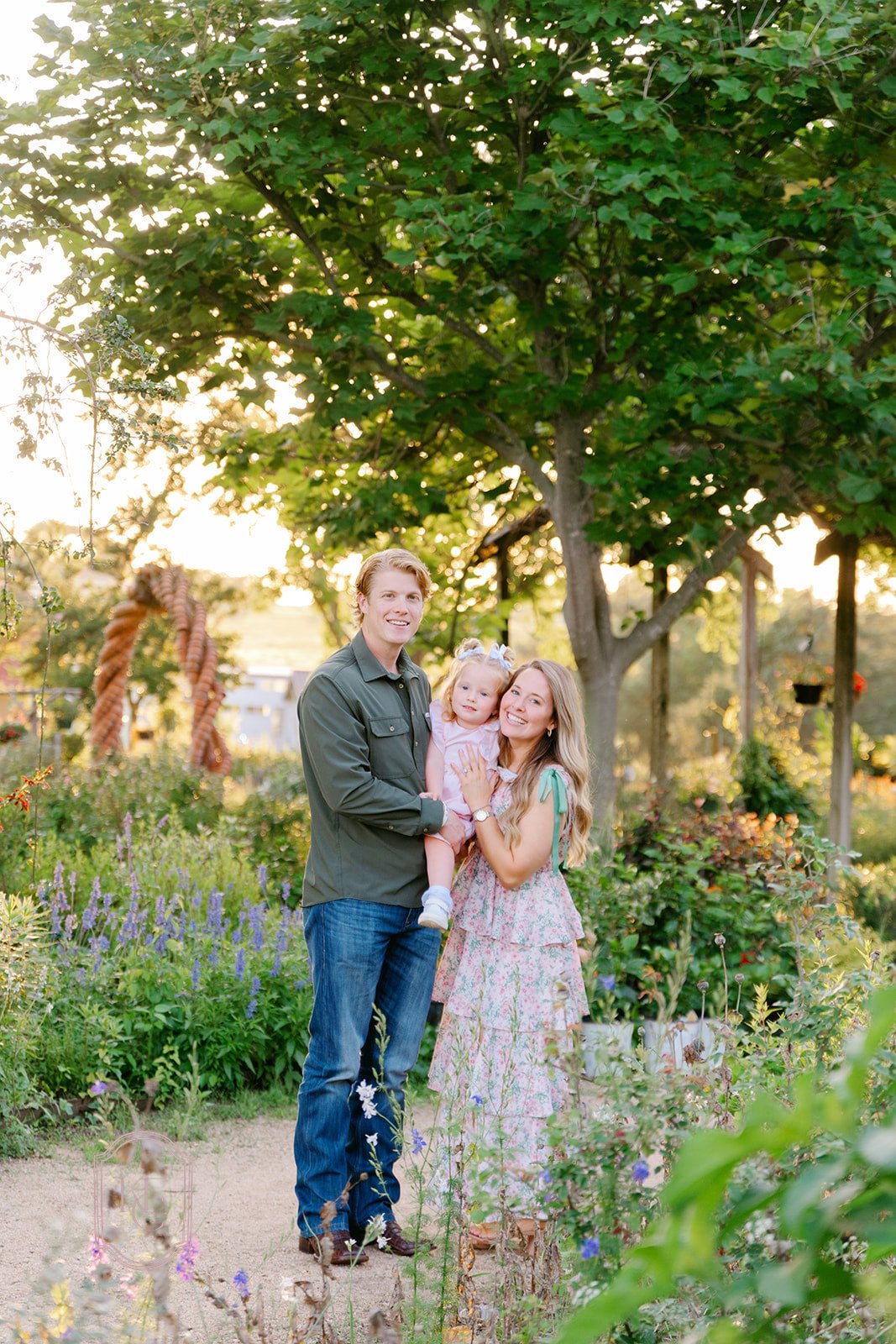 Family of 3 smiles for photoshoot at The Antique Rose Emporium