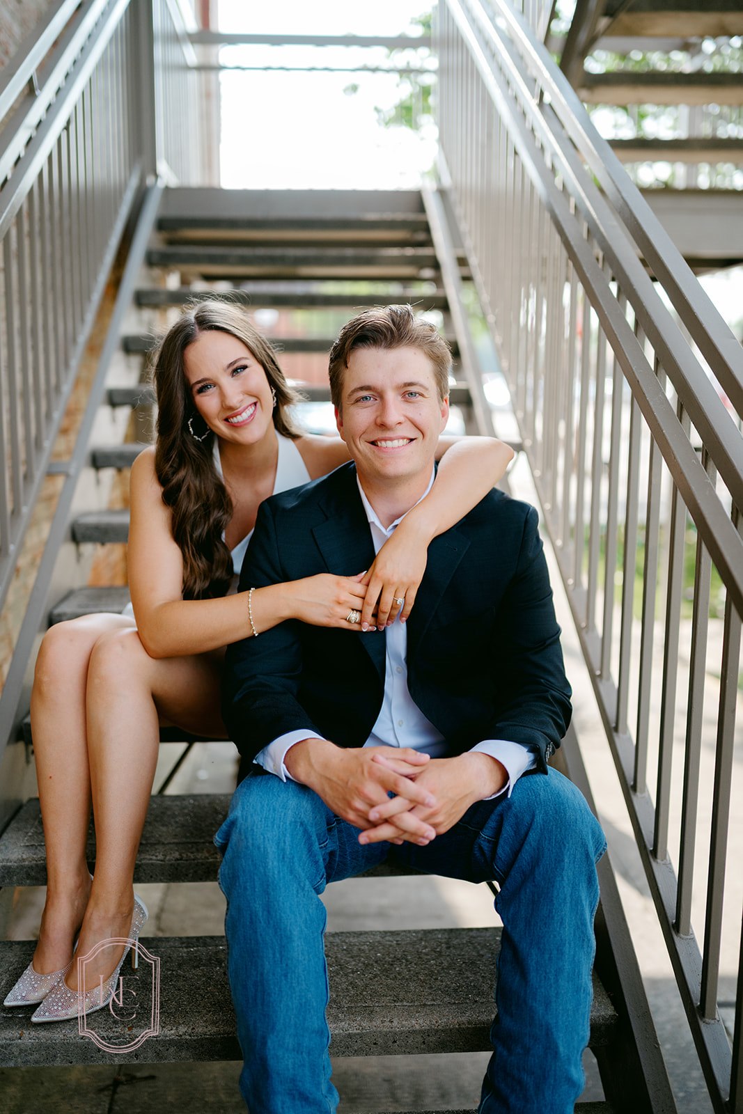 Couple smiles at camera during outdoor engagement photos