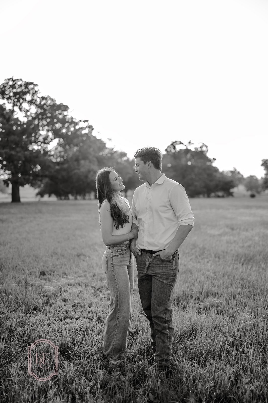 Man and woman smile at each other during outdoor engagement photos