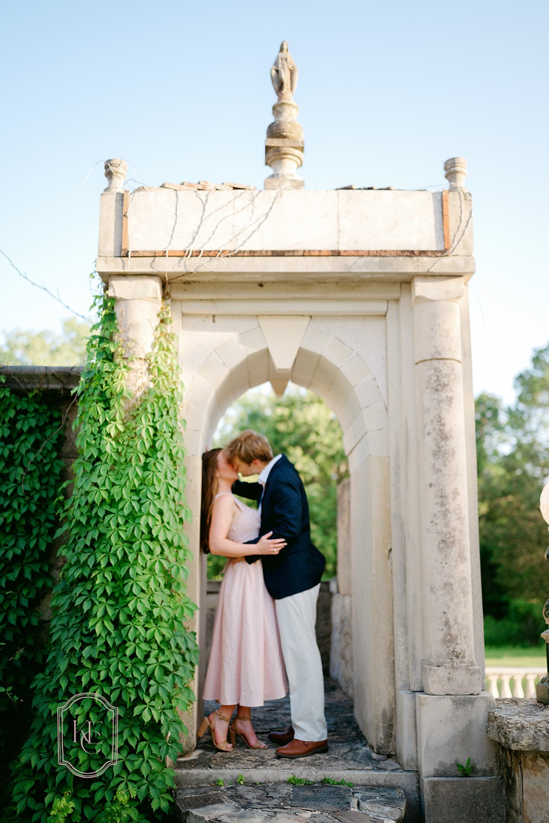 Couple kisses under arch at Festival Hill Institute photoshoot